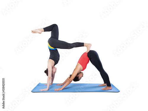 Two beautiful women doing yoga asana double isolated on white background.