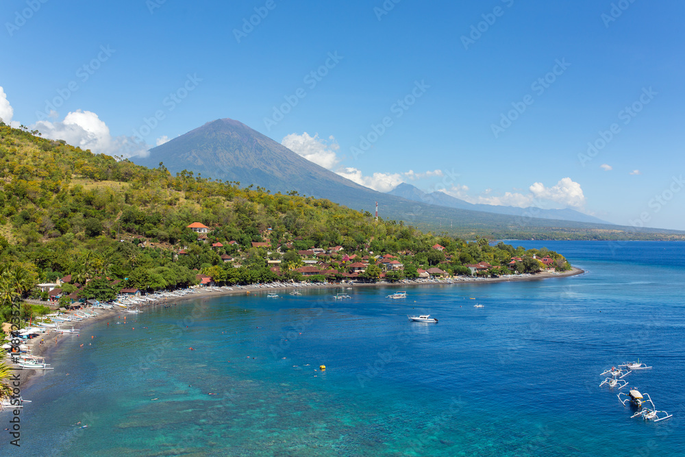 Jemeluk Beach and beautiful blue lagoon with Gunung Agung volcano on background.