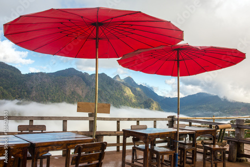 Beautiful outdoor cafe with traditional red Thai umbrellas in Northern Thailand.