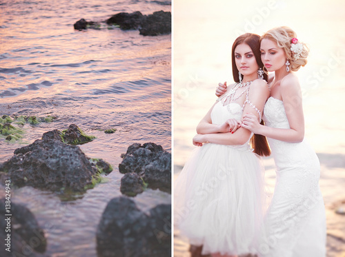 Young Two Brides in White Dreses Posing by the Sea on Sunset photo