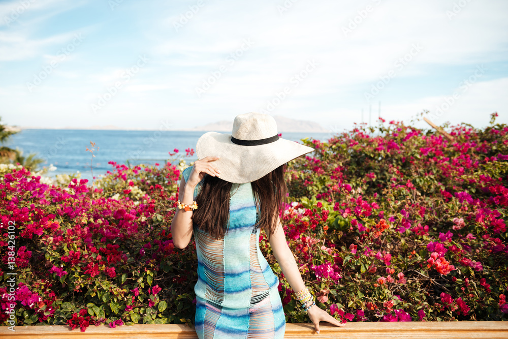 Woman in beachwear with flowers on background