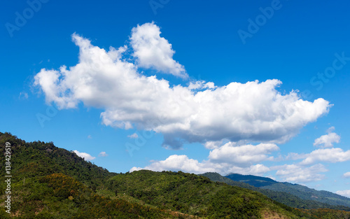 Mountains green grass  river  clouds and blue sky landscape.
