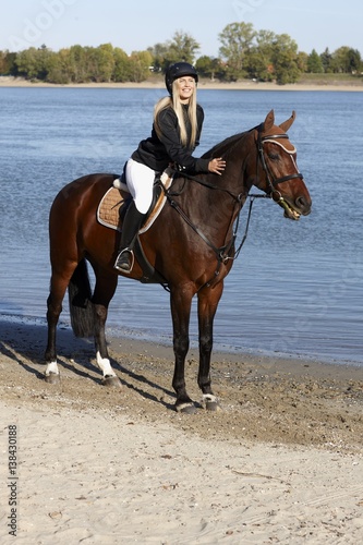 Horsewoman on horseback caressing horse