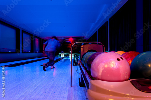 A Pink Bowling balls has ready for player to throwing ball on the wooden lane and in the bowling hall.