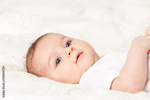 Baby girl is lying on bed
