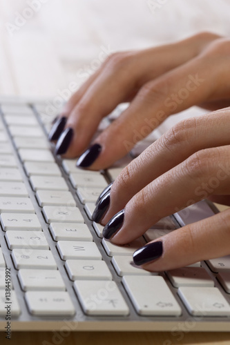 Woman with perfect manicure typing on keyboard