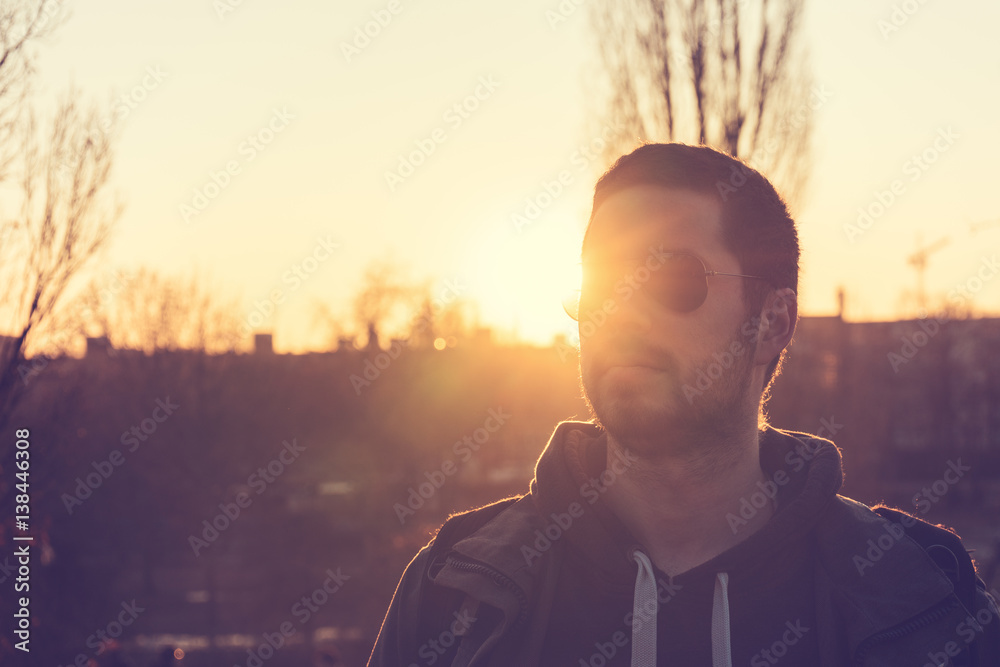 Young man in sunglasses with a sunburst