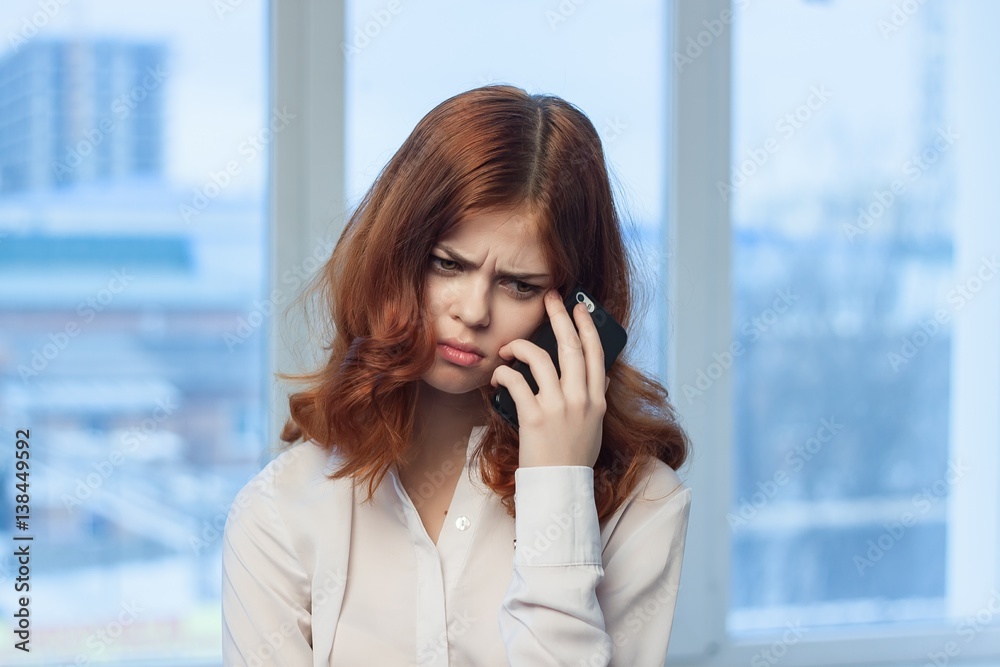 frustrated business woman standing near a window frustrated business woman standing near a window