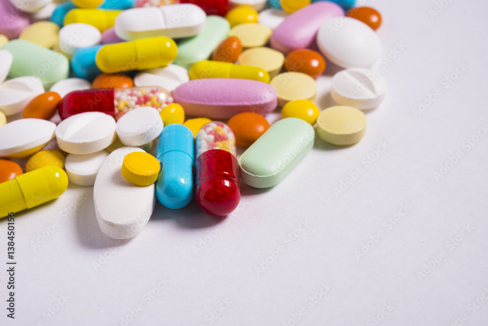 Multicolored pills and tablets on white background Multicolored pills and tablets on white background