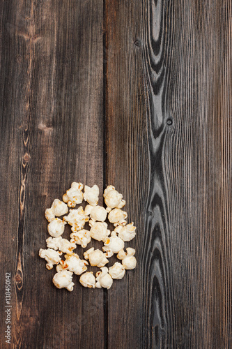 A handful of popcorn on a wooden table