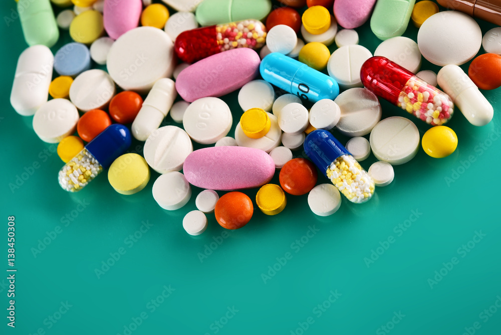 Multicolored pills and tablets on green background Multicolored pills and tablets on green background