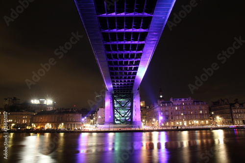 Striking view of the underside of the Tyne bridge in Newcastle-Upon-Tyne and the Quayside, both brightly lit photo