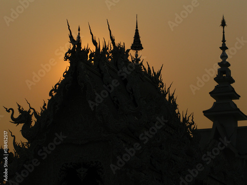 CHIANG RAI, THAILAND: beautiful and amazing Wat Rongkhun (White temple).  Black silhouette White Temple at sunset. White temple, Chiang Rai, Thailand.
 photo