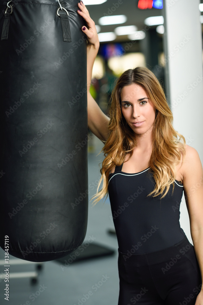 Female personal trainer with punching bag in a gym