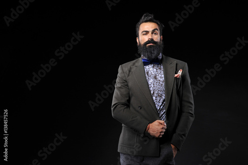 Bearded handsome man with suit on black background