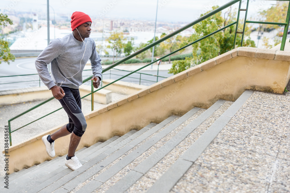 Black man running upstairs outdoors in urban background