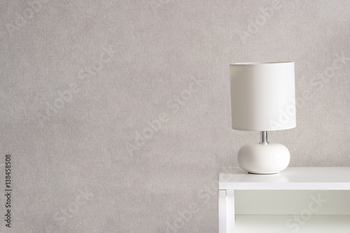 White Lamp on a commode. Grey background. Home concept