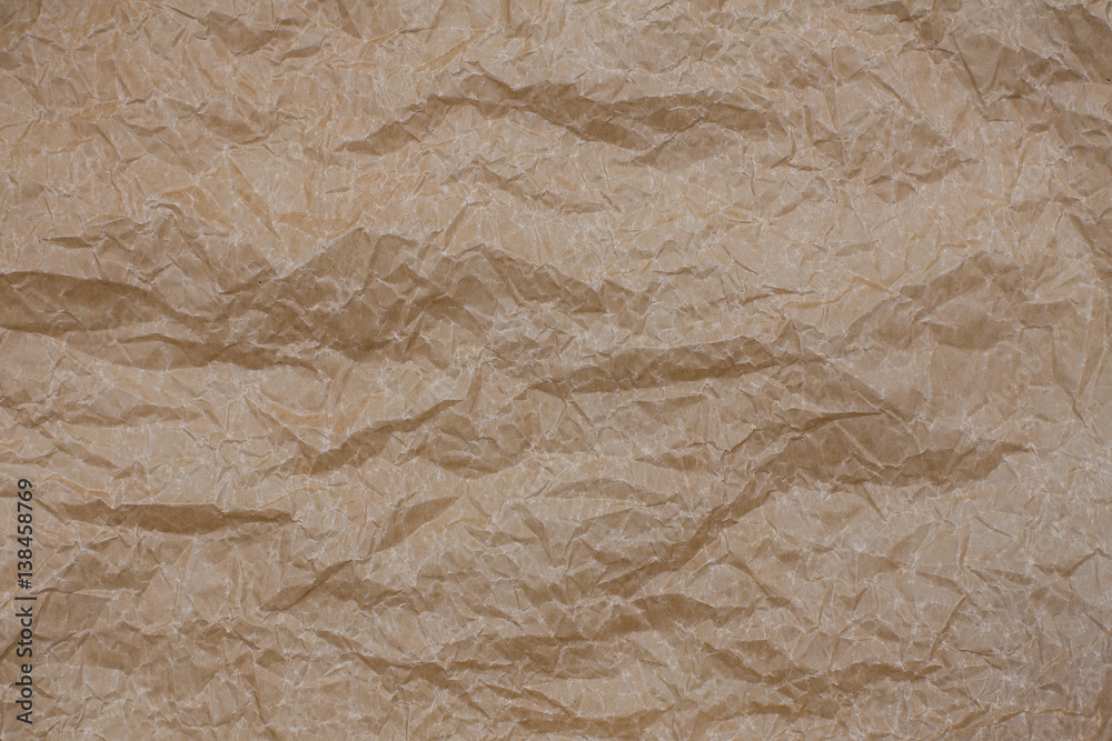 Fototapeta premium Wrinkled kraft paper. Top view brown crumpled paper background texture