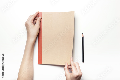 woman hand hold a note(book) with pencil isolated white. © dohee