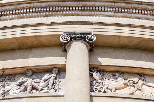 Ancient classical architecture. Ionic column. Roman soldier relief stone carving.