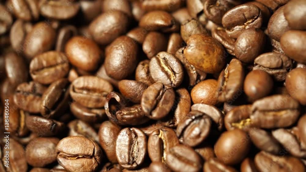 Motion of fresh roasted coffee beans background, which are ground in a coffee machine. Close up view from above. Motion of fresh roasted coffee beans background, which are ground in a coffee machine. Close up view from above.