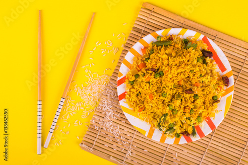 Pilaf with vegetables on bright background