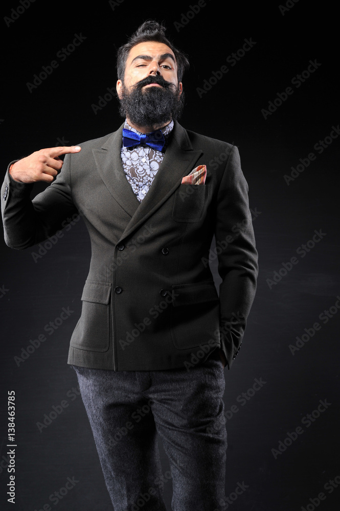 long bearded man in fashion suit on black background