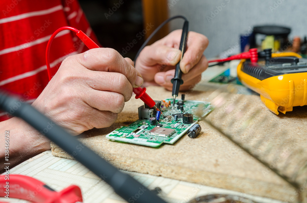 man hands closeup repair electronic device using Multimetr. tools man hands closeup repair electronic device using Multimetr. tools