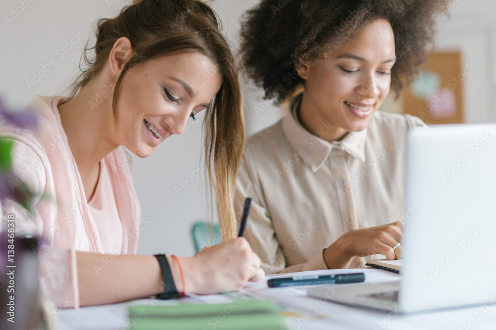 Businesswomen working together at the office desk.. Businesswomen working together at the office desk..