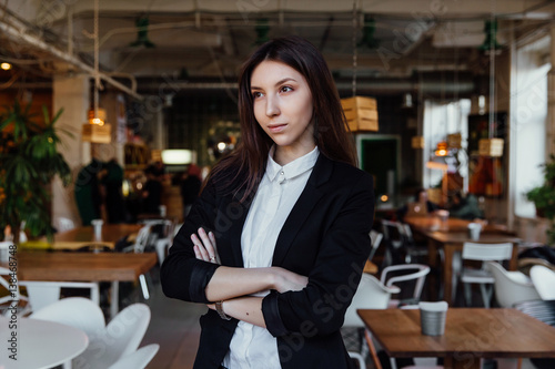 Portrait of a young cute brunette girl business in the interior hipster cafes. Long hair. © photominus21