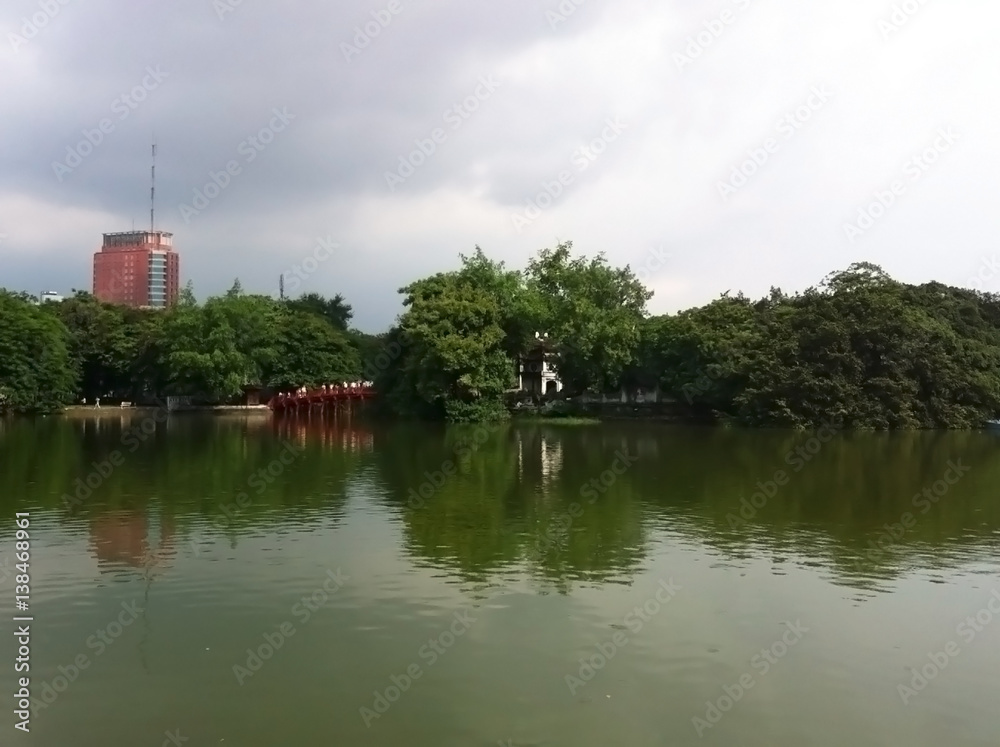 A city along a river in Vietnam, surrounded by tree and wild nature