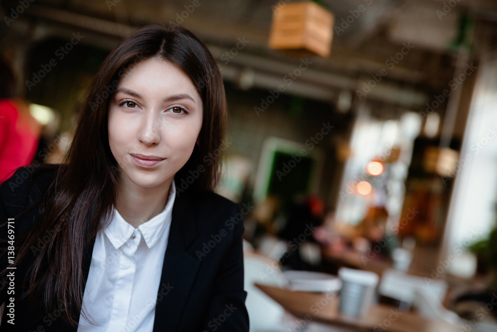 Close-up portrait beautiful brunette business girl. smiling and looking at the frame. space for text