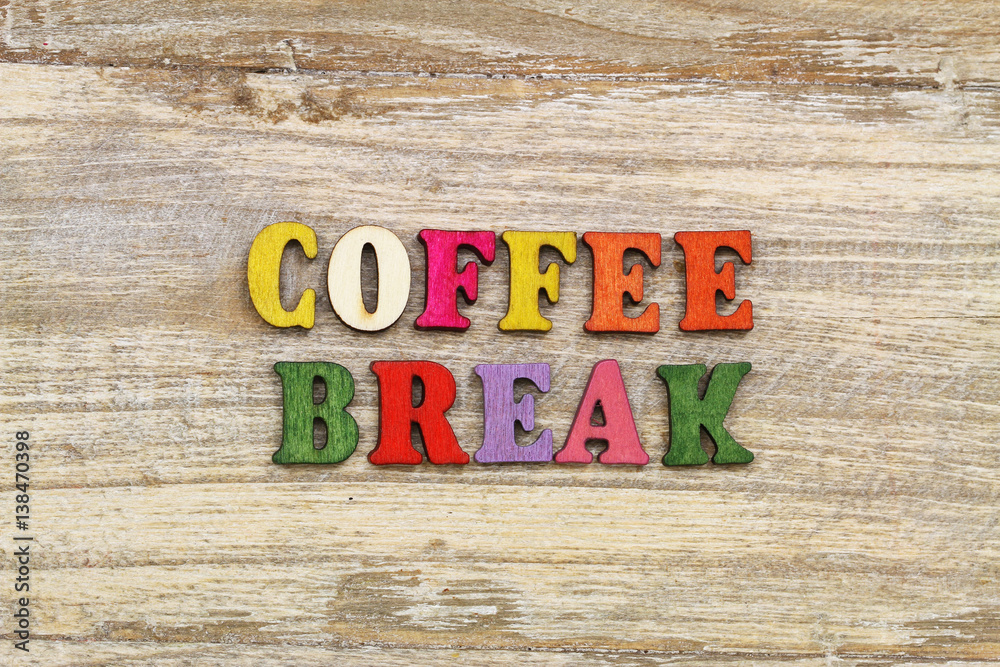 Naklejka premium Coffee break written with colorful letters on rustic wooden surface 