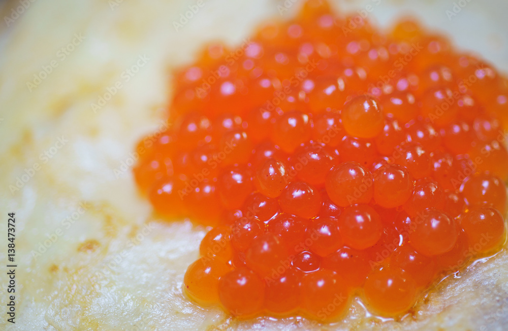 Holiday appetizer - red caviar on hot pancakes close-up. Holiday appetizer - red caviar on hot pancakes close-up.