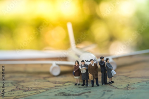 Miniature people : group of businessman passenger standing on world map in front of airplane waiting for boarding, business concept,  exploring on earth background concept.