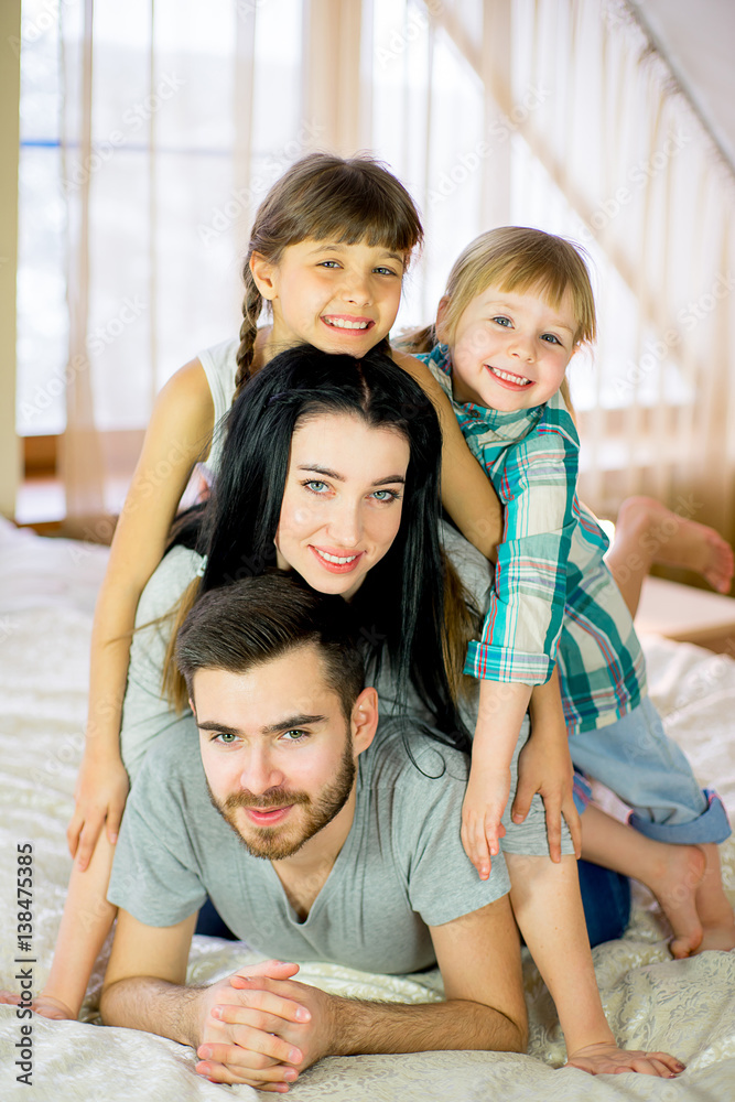 family posing on the bed in the hotel family posing on the bed in the hotel
