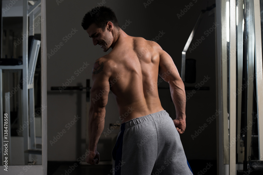 Muscular Man Flexing Back Muscles Pose Stock Photo