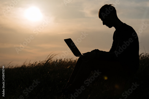 teamwork of two man at the top of mountain. silhouette at sunset