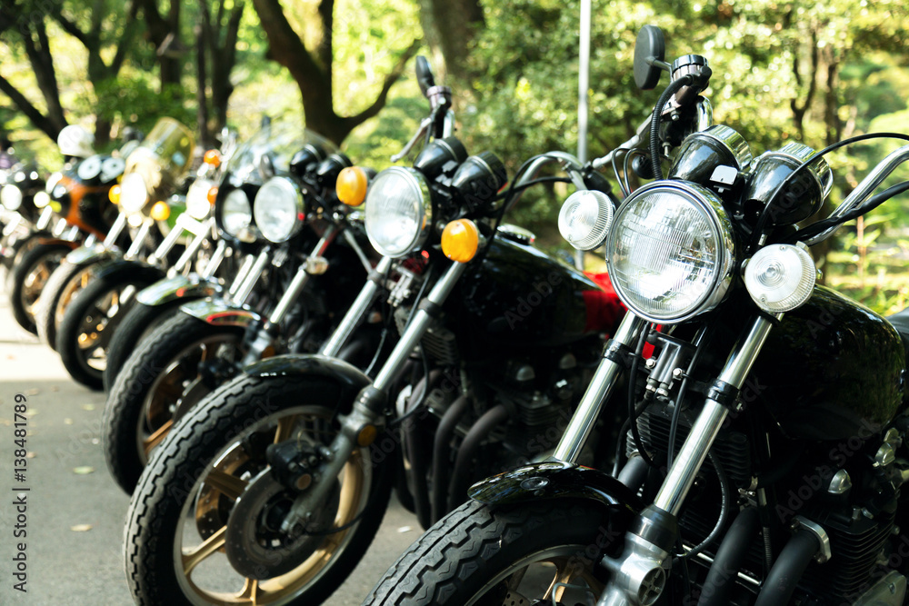 Fototapeta premium row of black classic vintage motorcycles parking and show in the park. selective focus.