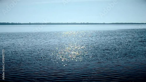 Water surface in a river or lake sparkling in the sun forming a sun way or path on water
