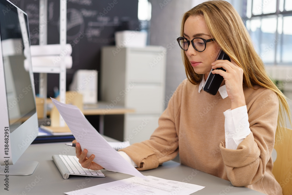 frau im büro mit telefon und unterlagen frau im büro mit telefon und unterlagen