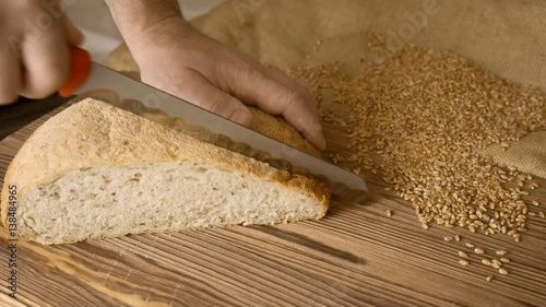 Cut slice of bread on the wooden table, in slow motion, close up