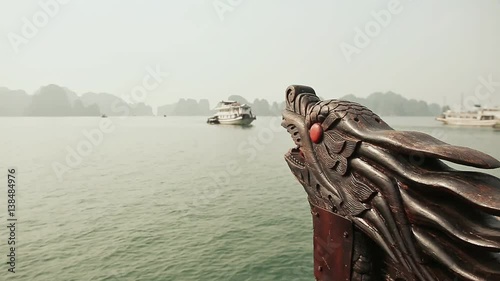 A boat with a dragon's head floating in the ocean. Vietnam. Ha Long Bay. photo