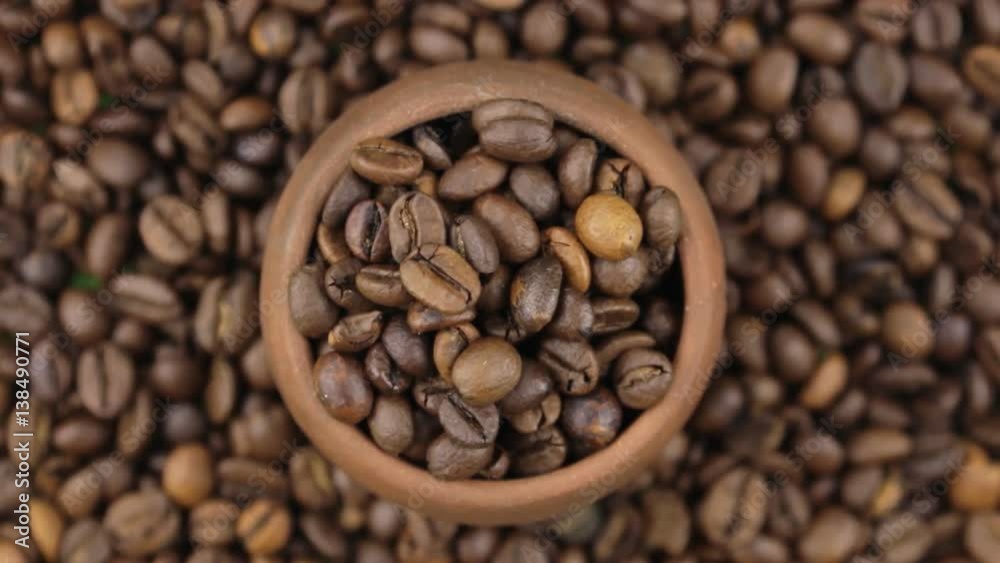 Slow rotation of the beans of coffee in a pot made of red clay. Slow rotation of the beans of coffee in a pot made of red clay.
