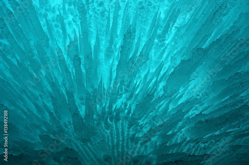 view from ice cave. frozen, crystal clear water drops like stalactites hang from the ceiling. rising sun stained ice. partially tinted photo. focus on a central object. Extra shallow depth of field.