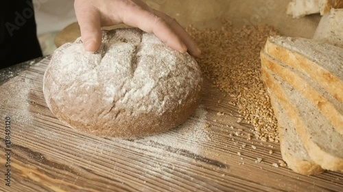 Cut slice of bread on the wooden table, in slow motion, close up