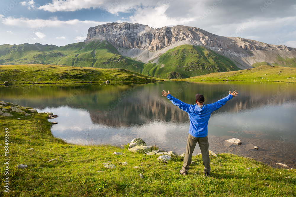 Man enjoying beautiful summer mountain landscape during his hiking trip