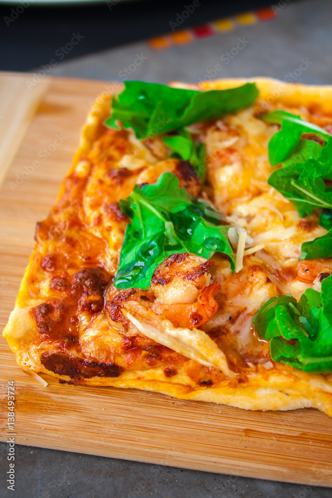 Pizza with basil, cheese and tomato in a wood table.