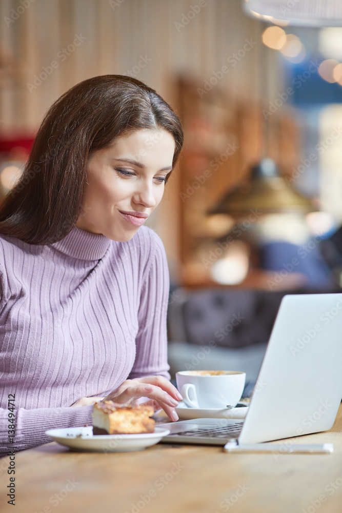 Beautiful brunette using laptop in cafe. Blogger work concept Beautiful brunette using laptop in cafe. Blogger work concept