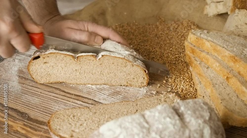 Cut slice of bread on the wooden table, in slow motion, close up